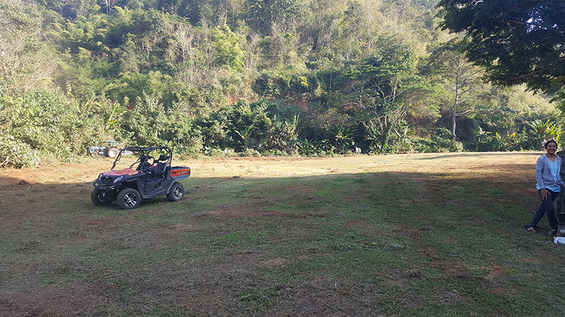 Wide view of cleared land with forested hills in the background